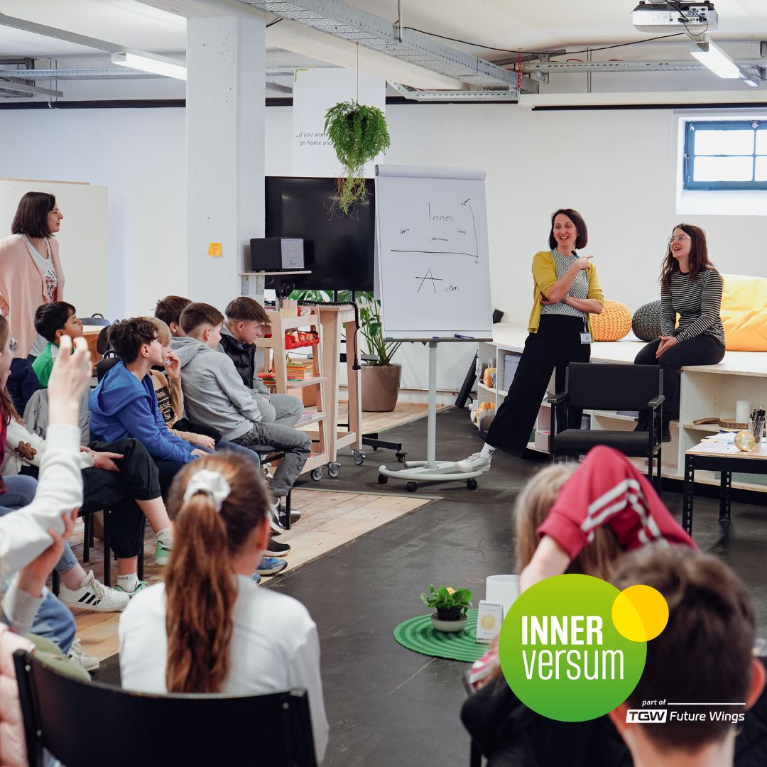 Ein Gruppe unterhält sich - Erwachsene und Jugendliche, das Logo des Innerversums ist zu sehen.