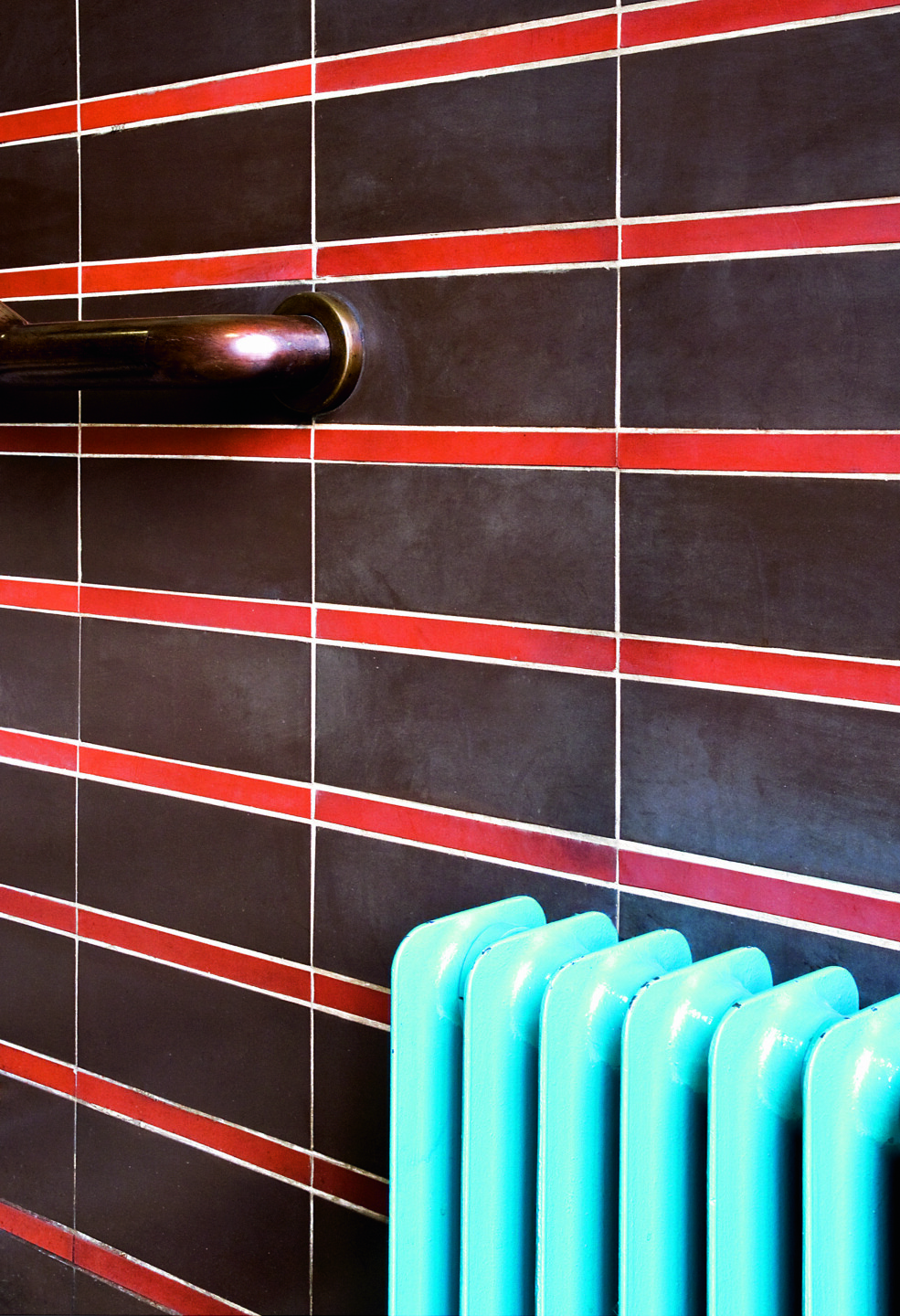 Dieses Farbspiel zeichnet die Tabakfabrik aus: Die Messingfarbe von Handgriffen, Türen etc., rote und braune Ziegel und das Linzer Blau, hier am Heizkörper.