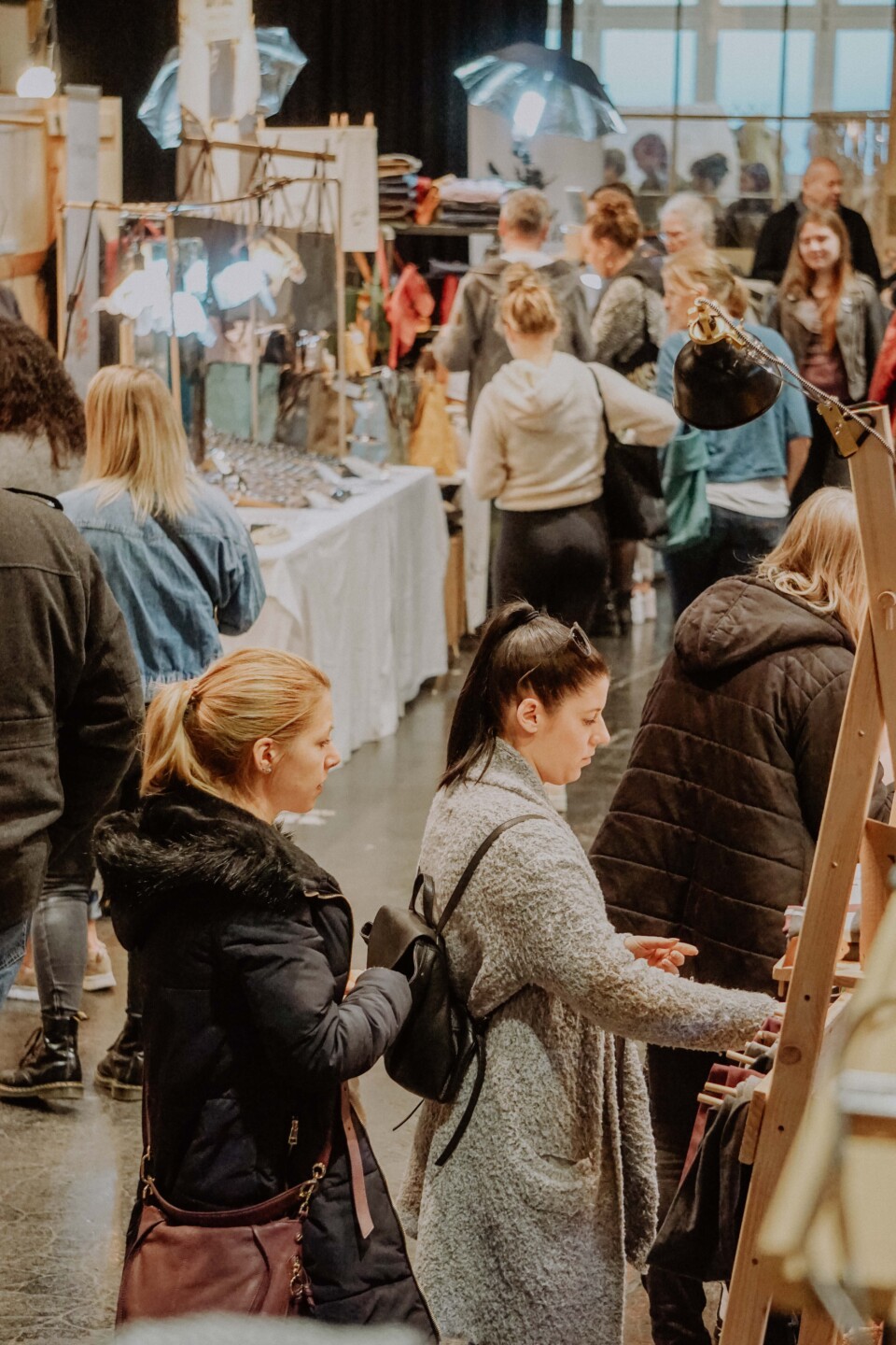 Einige Menschen schlendern durch den Kunst und Design Markt in der Lösehalle.